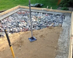 Mal built a raised cabin base foundation, filled it with rubble and sand to blinding level.