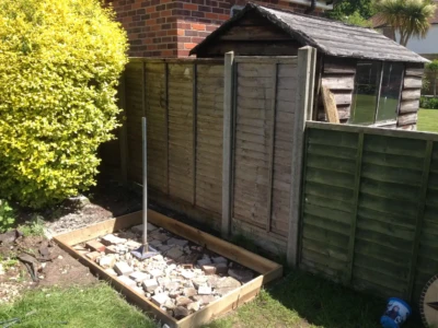 Mal fills and compacts voids prior to pouring a concrete foundation for the shed